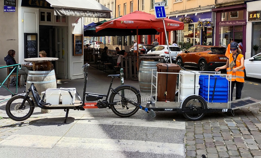 Une collectrice de OuiCompost charge la remorque vélo suite à une collecte de biodéchets effectuée chez un client profesionnel à Lyon.