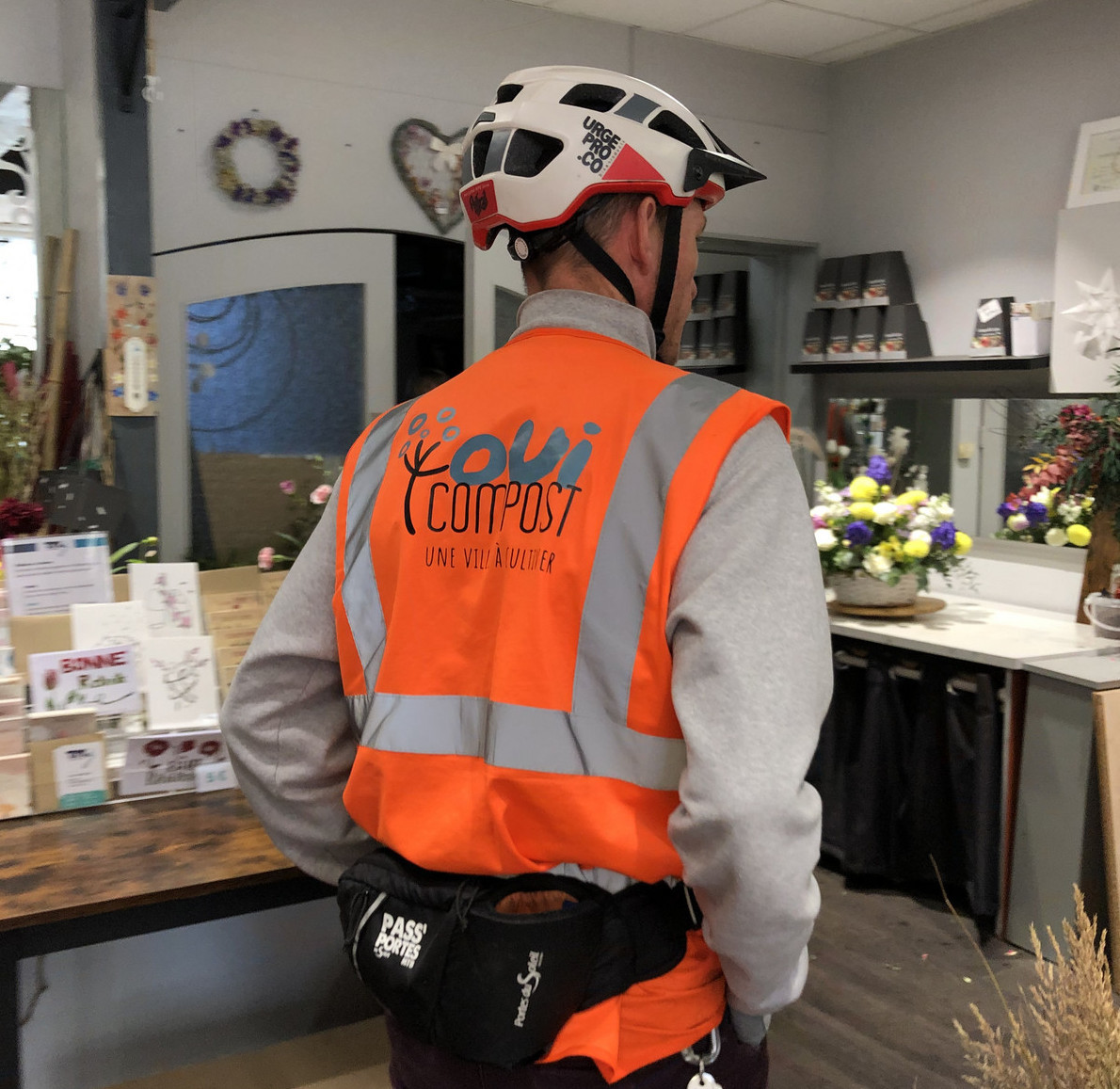 Collecteur OuiCompost entrant dans une boutique de fleuriste à Lyon pour récupérer des déchets verts dans le cadre d’un service clé en main de gestion des déchets alimentaires