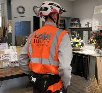 Service clé en main de gestion des biodéchets pour les commerces à Lyon Collecteur OuiCompost entrant dans une boutique de fleuriste à Lyon pour récupérer des déchets verts dans le cadre d’un service clé en main de gestion des déchets alimentaires