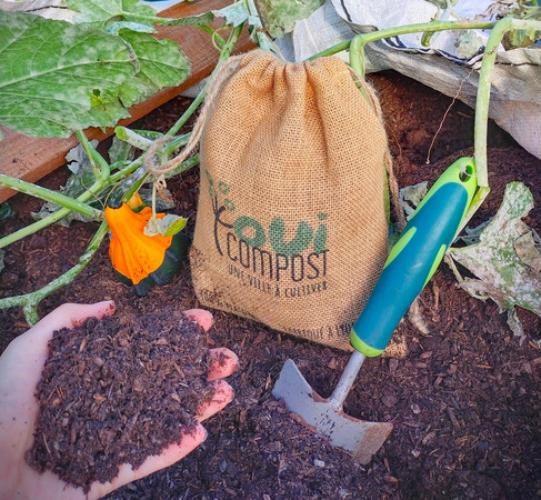 Compost acheter à Lyon chez OuiCompost Un sac de jute avec le logo de OuiCompot est posé sur un tas de compost produit à Lyon par la société de valorisation des déchets alimentaires des professionnels à Lyon OuiCompost.